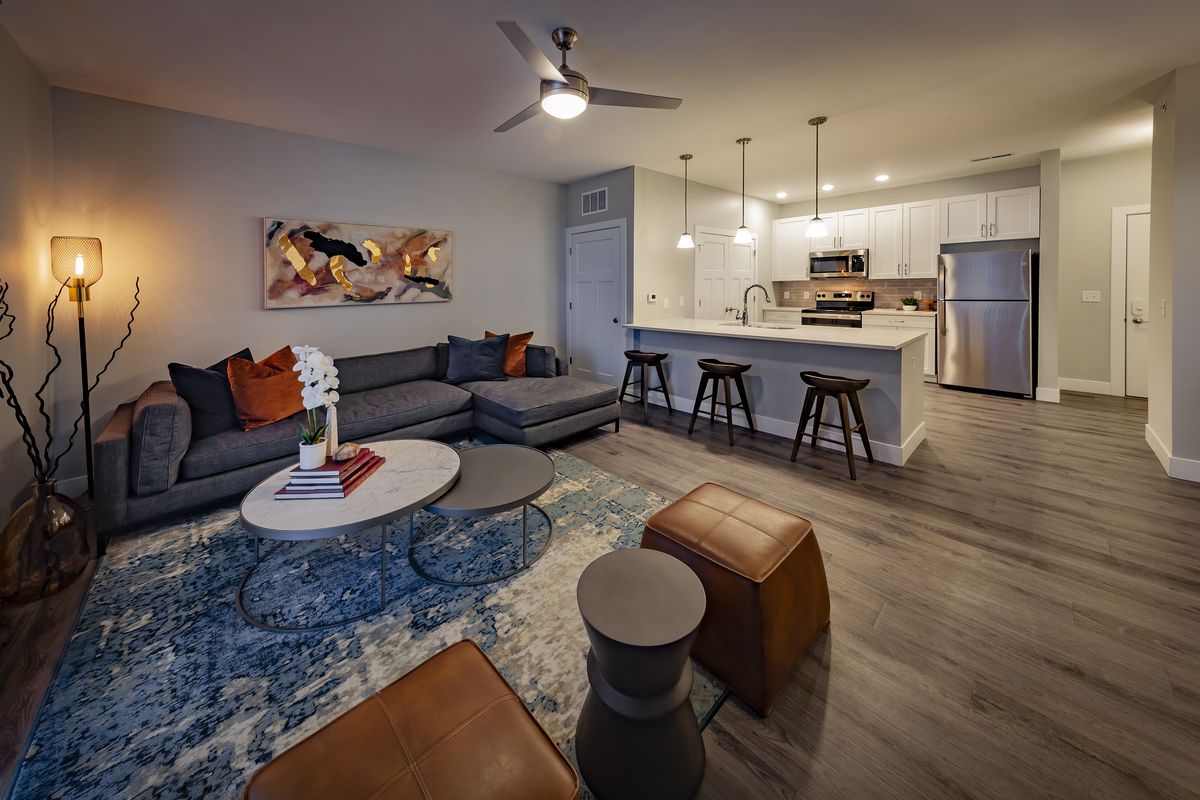 Modern open-concept living room and kitchen with stainless-steel appliances